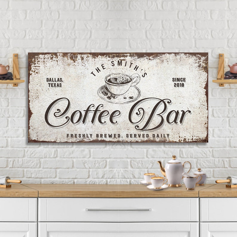 May include: A white and brown vintage-style sign with the text "The Smith's Coffee Bar" in a cursive font. The sign also includes the text "Dallas, Texas" and "Since 2018". The sign features a drawing of a cup of coffee with steam rising from it.