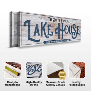 以下が含まれることがあります： 「LAKE HOUSE」の文字が紺色で書かれた木製の看板。その下に「LAKE ARROW HEAD, CA EST. 2010」と書かれています。看板は白とグレーの木製の背景に取り付けられています。「THE SMITH FAMILY」の文字が「LAKE HOUSE」の上にあります。