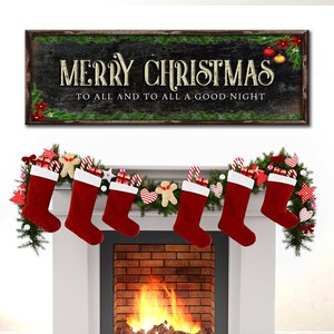 May include: A black chalkboard sign with the text "Merry Christmas to all and to all a good night" surrounded by a green garland. A fireplace with a fire burning in it is decorated with a garland of greenery and red stockings.