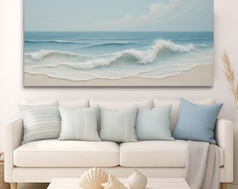 Peut inclure: Une grande toile rectangulaire représentant une scène océanique avec des vagues déferlant sur une plage de sable. L'œuvre utilise des nuances de bleu et de blanc, avec un ciel bleu clair et des nuages ​​duveteux. L'impression est au-dessus d'un canapé blanc.