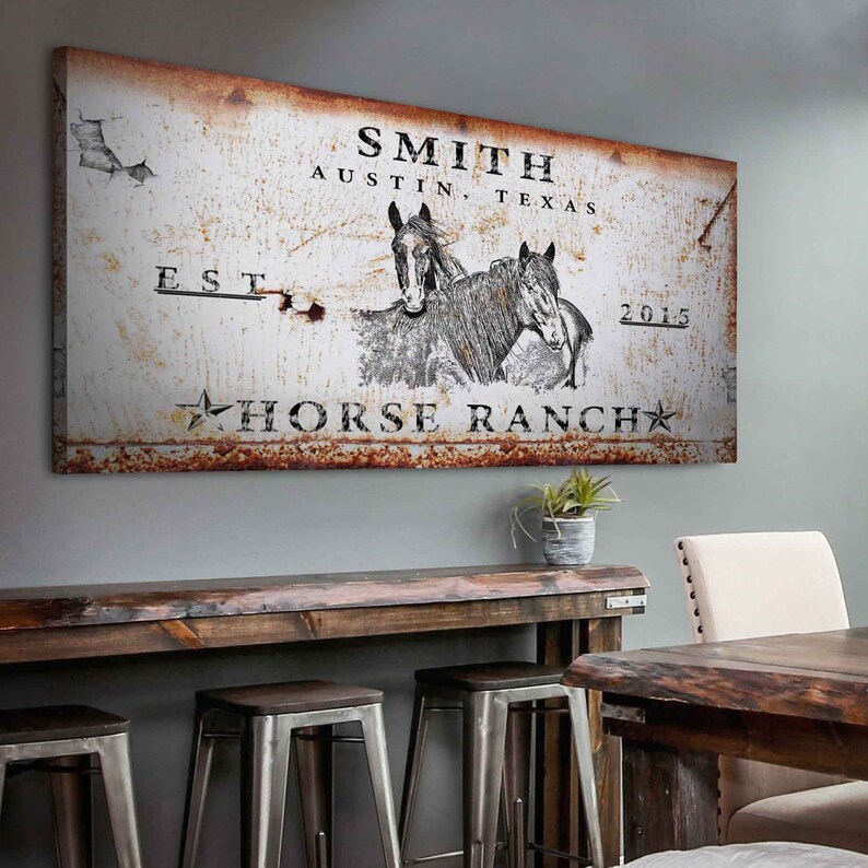 May include: Rustic metal sign with a white background and brown rust accents. The sign features the text "SMITH AUSTIN, TEXAS EST. 2015 HORSE RANCH" with a star on either side of the text. Two horses are depicted in black and white in the center of the sign.