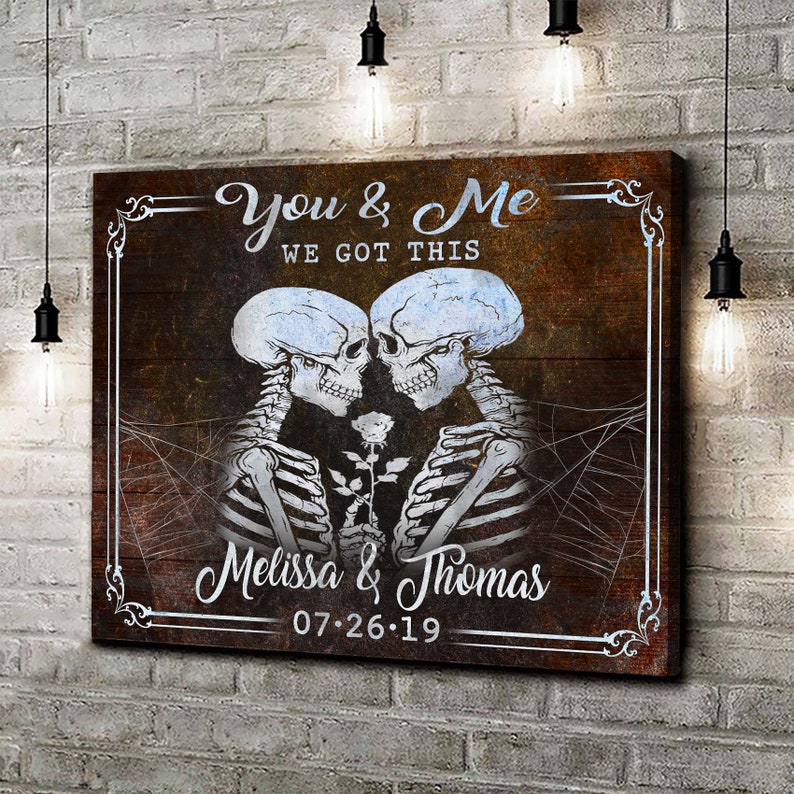 May include: A brown wooden canvas print with a white border. The print features two skeletons holding a white rose and the text "You & Me We Got This Melissa & Thomas 07.26.19".
