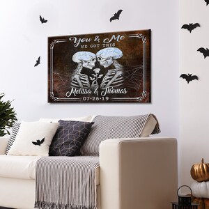 May include: A rustic wooden sign with a couple of skeletons holding a rose. The sign reads "You & Me We Got This Melissa & Thomas 07-26-19".