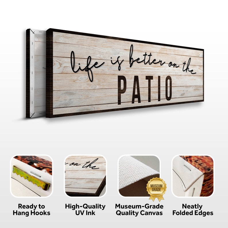 May include: A wood-look canvas print with the text "life is better on the PATIO" in black script font. The print has a distressed white wood background with a dark brown frame. The print is ready to hang with sawtooth hangers on the back.