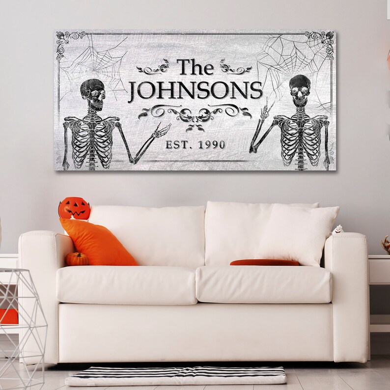 May include: A black and white Halloween-themed sign with two skeletons, a spiderweb, and the text "The Johnsons Est. 1990".