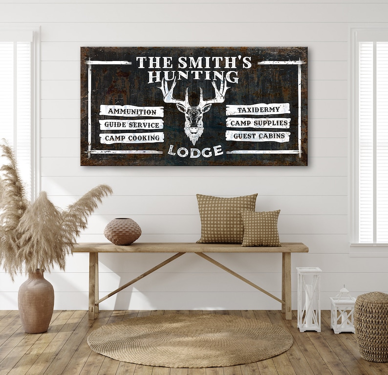 May include: A rustic wooden sign with the text "The Smith's Hunting Lodge" and a white silhouette of a deer head. The sign lists services offered, including ammunition, guide service, camp cooking, taxidermy, camp supplies, and guest cabins.