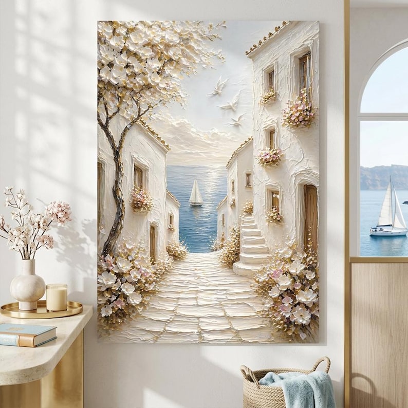 May include: A textured oil painting on canvas depicting a Mediterranean coastal scene with white stone buildings, a cobblestone path leading to a blue sea, a sailboat, a large flowering tree, and white birds flying in a soft, light-filled sky.