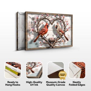 May include: A canvas print featuring a pair of red cardinals perched on a heart-shaped branch with pink blossoms. The background is a rustic woodgrain pattern. The print has a wooden frame and is ready to hang.
