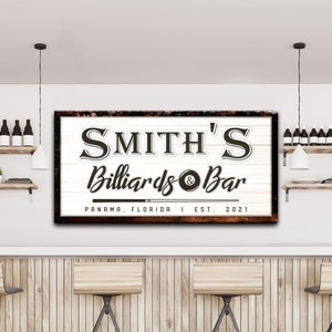 Puede incluir: Un letrero de madera blanco con bordes marrones desgastados y texto que dice "Smith's Billiards & Bar", "Panam&aacute;, Florida", y "Est. 2021".