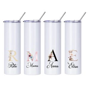 Könnte beinhalten: Vier weiße Edelstahlbecher mit Strohhalm, jeder mit einem Blumendesign und einem Buchstaben des Alphabets. Die Becher sind mit den Namen Rita, Mama, Anna und Elisa beschriftet.