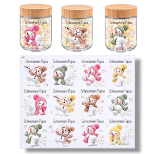 Könnte beinhalten: Drei klare Gläser mit hellen Holzdeckeln gefüllt mit Mini-Marshmallows, jedes mit einem Schneemann-Motiv und dem Text "Schneemann Pupse". Darunter befinden sich zwölf Aufkleber-Designs mit verschiedenen Schneemännern und dem Text.