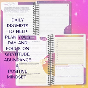 May include: A pink and purple planner with a spiral binding. The cover has the text "Daily Free Flow" and "Daily Prompts to Help Plan Your Day and Focus on Gratitude, Abundance & Positive Mindset". The inside pages have a daily schedule and prompts for gratitude, abundance, and positive mindset.