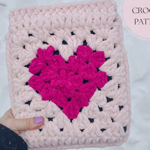 May include: Pink and fuchsia crochet square with a heart design. CROCHET PATTERN text is in the upper right corner of the image.