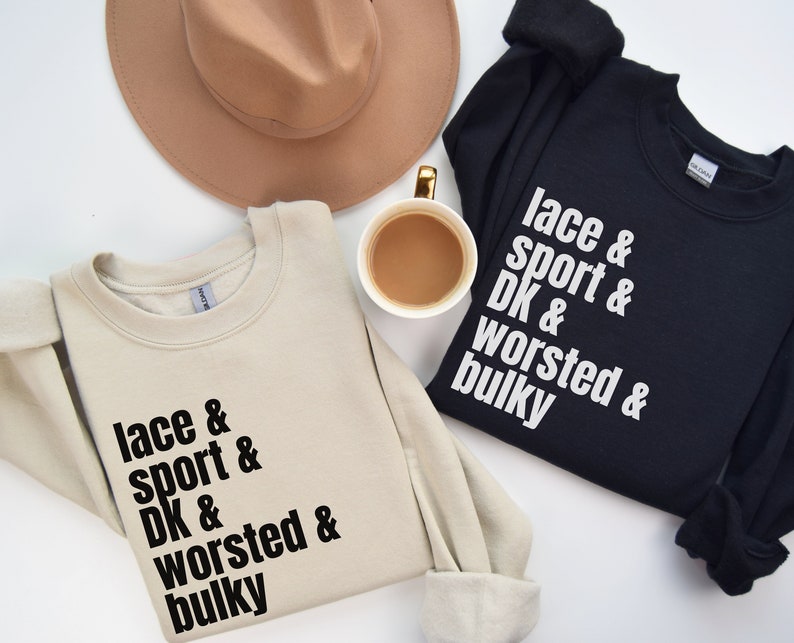 Op de afbeelding: Twee sweatshirts met de tekst "lace & sport & DK & worsted & bulky" erop gedrukt. E&eacute;n sweatshirt is beige en de andere is zwart.