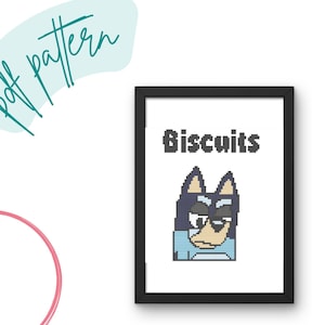 Könnte beinhalten: Ein schwarzer gerahmter Kreuzstich-Muster mit einem Cartoon-Hund und dem Text "Biscuits" darüber.