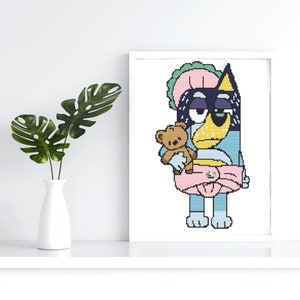 Könnte beinhalten: Ein blauer und schwarzer Cartoon-Hund, der eine rosa Windel und eine rosa-grüne Haube trägt, hält einen braunen Teddybären. Der Hund hat einen müden Ausdruck.