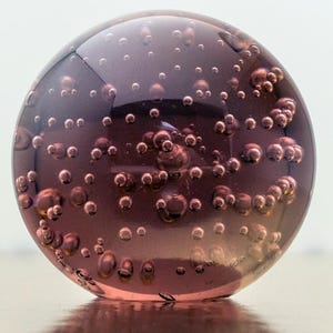 Peso de papel de vidro. Esfera de bolhas rosa-púrpura. Vintage escocês, década de 1970.