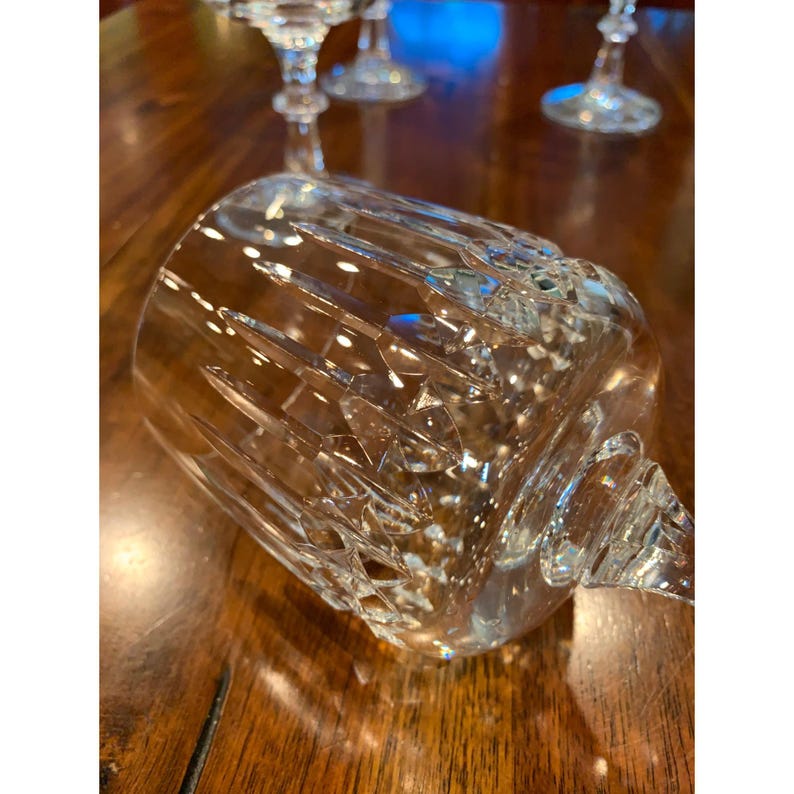 May include: Close-up of a clear glass goblet with a cut crystal design. The goblet has a wide bowl and a tall stem.