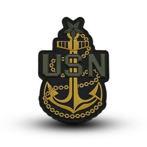 May include: A black and gold embroidered patch with a stylized anchor, a star, and the text "USN".