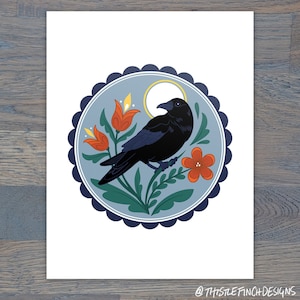 May include: A black crow perched on a branch with red and orange flowers in a blue and white circular frame. The crow is facing right and has a yellow moon behind it.