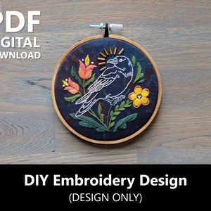 May include: A digital embroidery design featuring a black bird with a yellow flower and orange flowers on a dark blue background. The design is in a hoop and the text "DIY Embroidery Design (DESIGN ONLY)" is below the hoop.