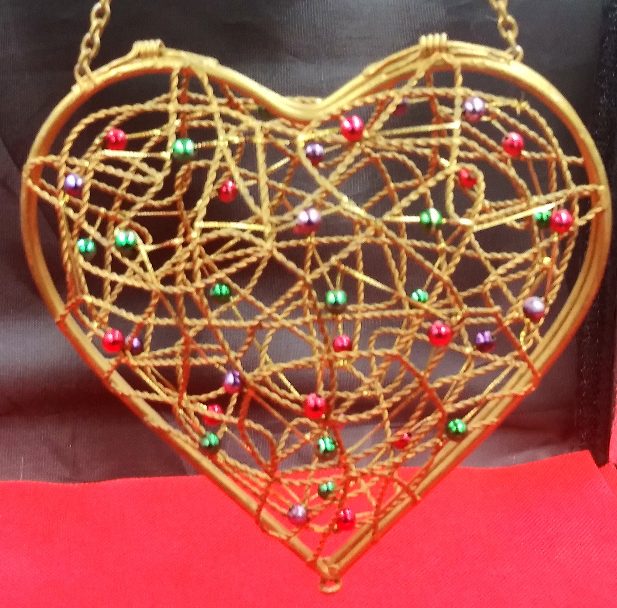 boîte/panier à bibelots en forme de coeur fil métallique ouvert. perlage rouge/vert/violet. couvercle charnière. chaîne pour accrocher