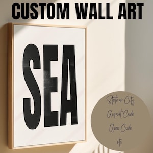 May include: A custom wall art print with the word "SEA" in bold black letters on a white background. The print is framed in a light wood frame.