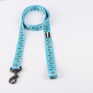 May include: A light blue dog leash with a repeating pattern of avocado illustrations. The leash has a silver clip.