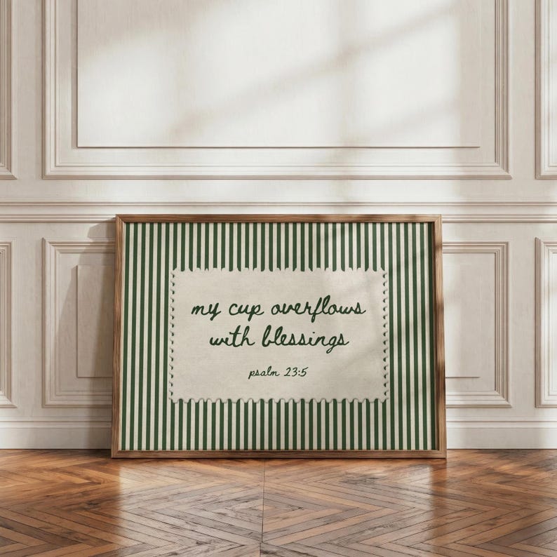Framed artwork with green stripes and text "my cup overflows with blessings psalm 23:5".