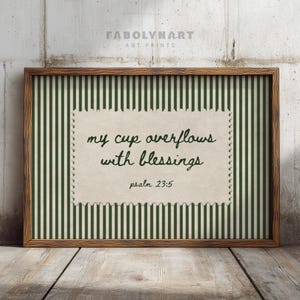 Framed wall art with green stripes and text "my cup overflows with blessings, psalm 23:5".