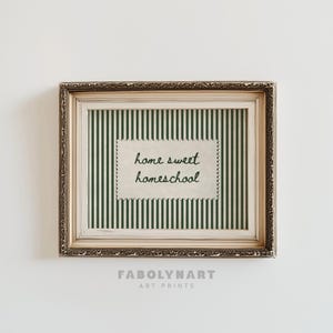 Ornate framed print with "home sweet homeschool" text on green stripes.