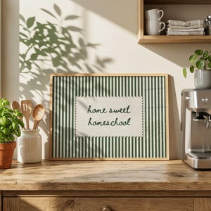 Framed artwork with green and white stripes, saying "home sweet homeschool."