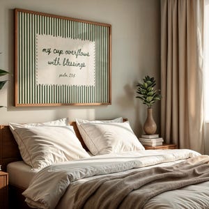 Framed art with green stripes reads "my cup overflows with blessings psalm 23:5".