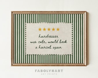 May include: A framed art print featuring a dark green and white vertical striped background. Centered is a cream-colored, postage stamp-shaped label with five gold stars and the text: hairdresser was cute, would book a haircut again.