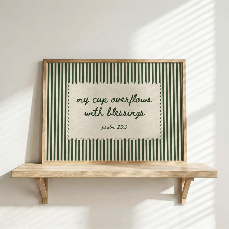 Framed art with green stripes and text "my cup overflows with blessings psalm 23:5".
