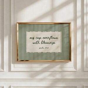 Framed artwork with green stripes and quote "my cup overflows with blessings."
