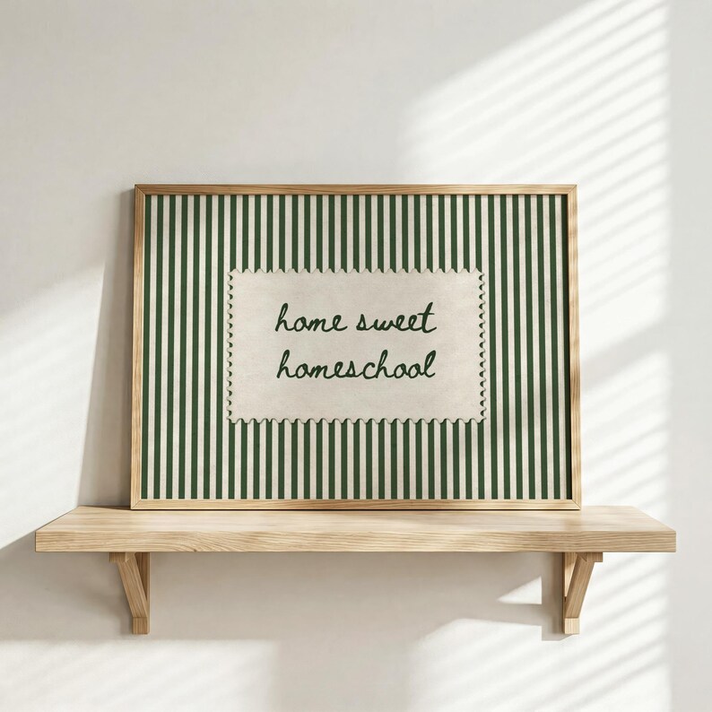 Framed print with green stripes and "home sweet homeschool" text on a shelf.