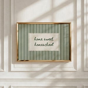 Framed artwork with green stripes and "home sweet homeschool" text on a scalloped tag.