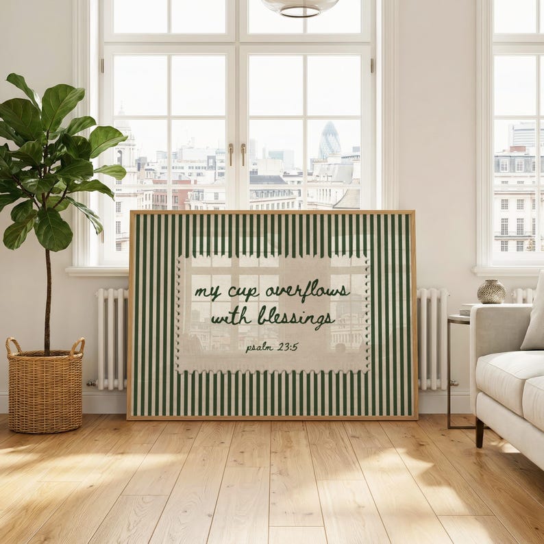 Framed artwork with green and white stripes features text: "my cup overflows with blessings psalm 23:5".