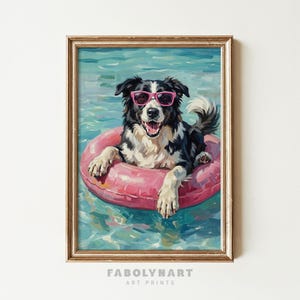May include: A framed art print of a Border Collie dog wearing pink sunglasses and floating in a pink inflatable ring in a pool. The dog has black and white fur and is smiling. The water is a light blue color. The print is labeled "FABOLYNART ART PRINTS".