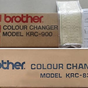 May include: Two cardboard boxes labeled "brother COLOUR CHANGER" with model numbers KRC-900 and KRC-830. The top box has red rectangular accents. Accompanying the top box are papers and a plastic bag with printed content.
