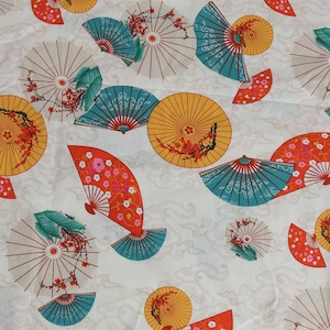 Puede incluir: Tela blanca con un patrón repetido de abanicos coloridos y diseños florales. Los abanicos son en tonos de rojo, naranja, azul y verde.