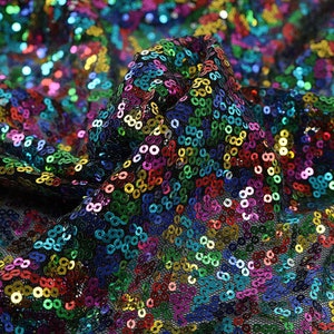 May include: A close-up of a fabric with a rainbow of sequins. The sequins are sewn onto a black mesh fabric.
