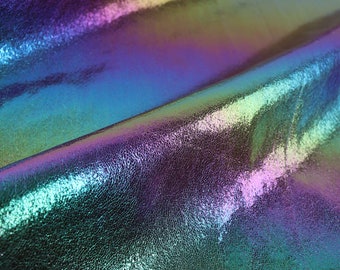 May include: Close-up of iridescent fabric with a textured surface. The fabric has a blue, green, and purple color shift.