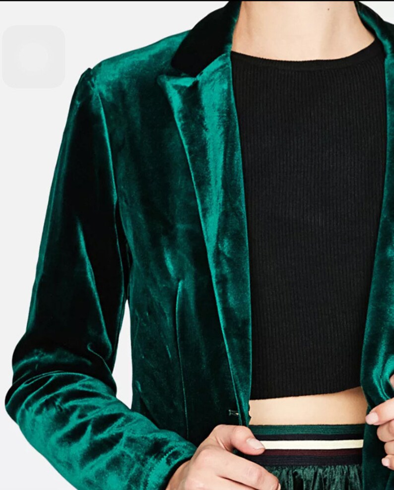 Op de afbeelding: Een donkergroen fluwelen blazer met een zwarte kraag. De blazer heeft een enkele knoopsluiting en lange mouwen.