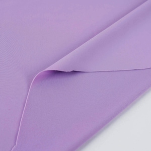 May include: A close-up of a soft, lilac-colored fabric. The fabric is folded in half, showing the texture of the material.