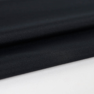 May include: Close-up of a black, textured fabric with a subtle ribbed pattern. The fabric is folded and draped, showcasing its smooth and soft texture.