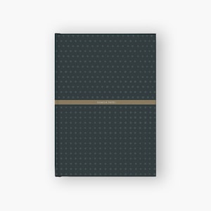 May include: A dark blue notebook with a subtle pattern of small white dots. The notebook has a tan band with the name "Kamila Patel" printed on it.