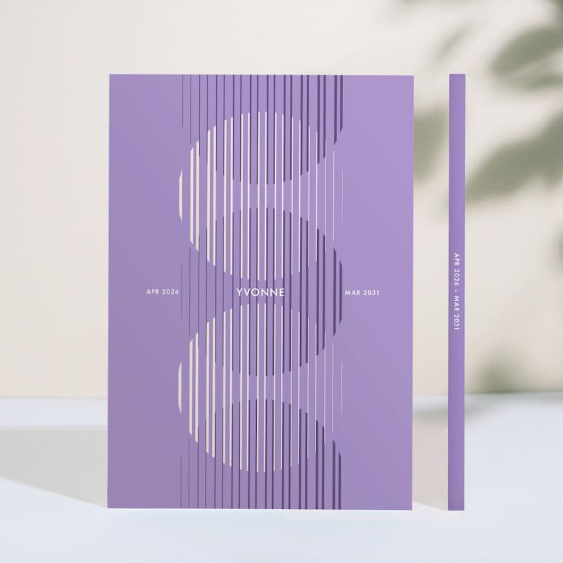 May include: A lavender-colored notebook with a vertical design of white and dark purple lines. The name "YVONNE" is centered, with "APR 2026" and "MAR 2031" on either side. The spine shows "APR 2026 - MAR 2031".