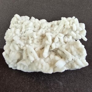 May include: A trio of ceramic mugs with a speckled, matte finish in cream, light grey, and dark grey. Each mug features a simple, minimalist design, ideal for tea or coffee.